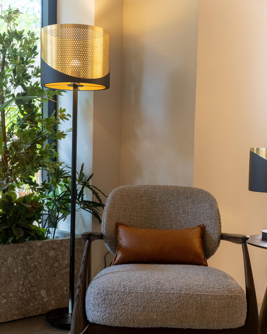 Dip floor lamp with sleek vertical stainless steel design casting warm ambient light / مصباح أرضي بتصميم طولي أنيق من الستانلس يوفّر إضاءة دافئة وعصرية